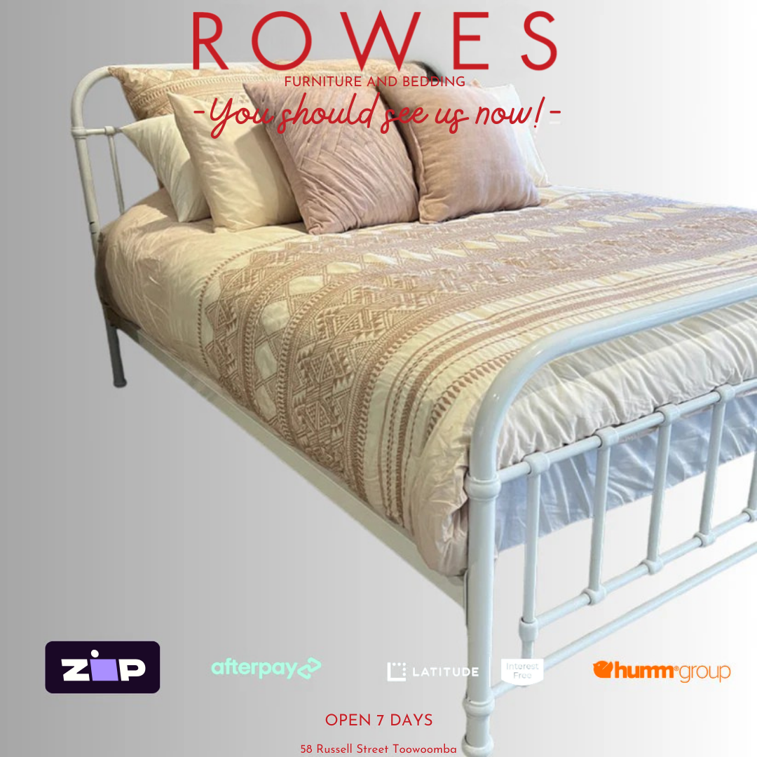 A white, metal Akira bed frame with a mattress and pillows on it, advertised by ROWES furniture and bedding.