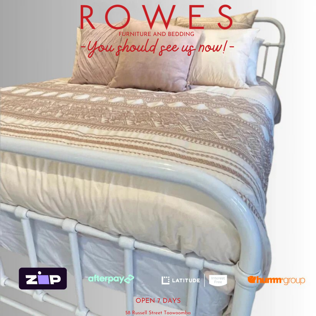 A white, metal Akira bed frame with a mattress and pillows on it, advertised by ROWES furniture and bedding.
