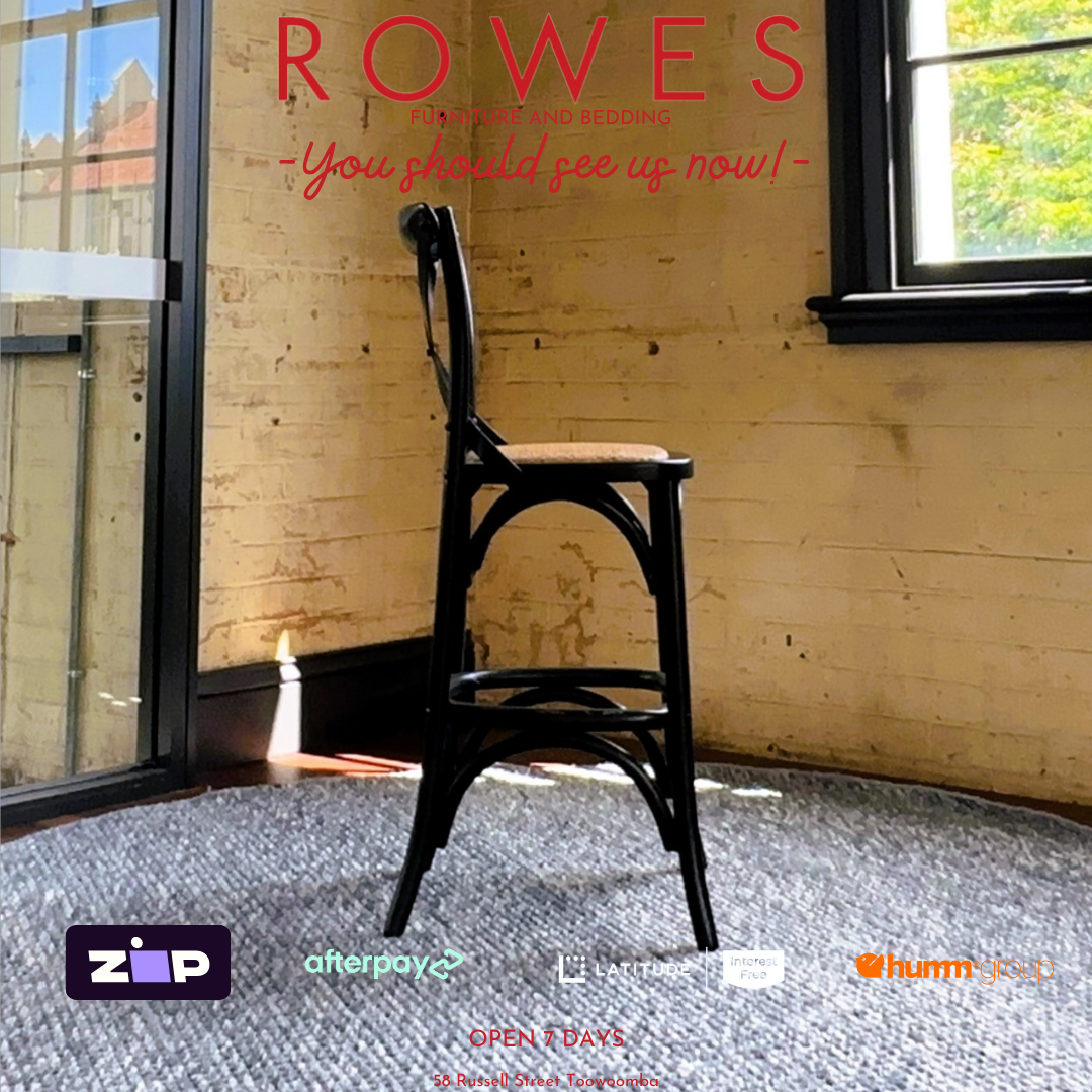 Black wooden chair in a room with wooden walls and large windows, featuring the brand 'Rowes'.