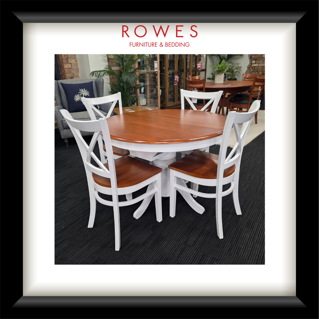 A white dining table surrounded by matching chairs. The top of the dining table and the seats of the chairs are all natural timber coloured. The Rowes branding is prominent.