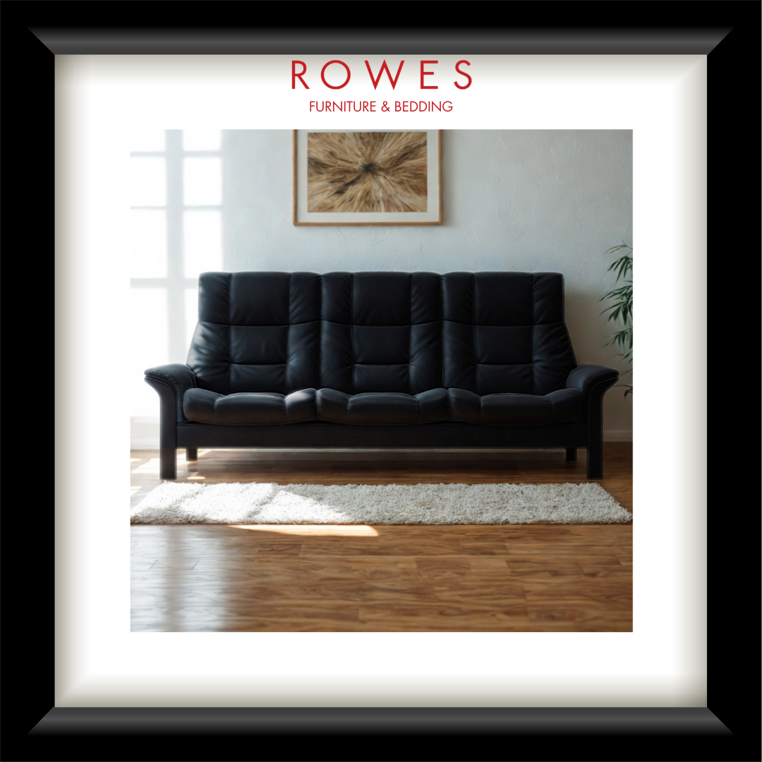 Black sofa in a living room with 'Rowes Furniture & Bedding' branding.