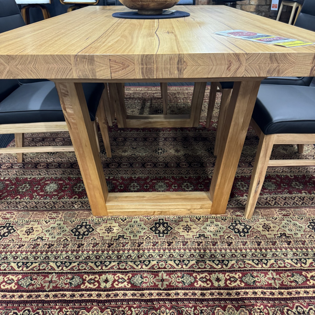 Wooden dining table with chairs on a patterned rug