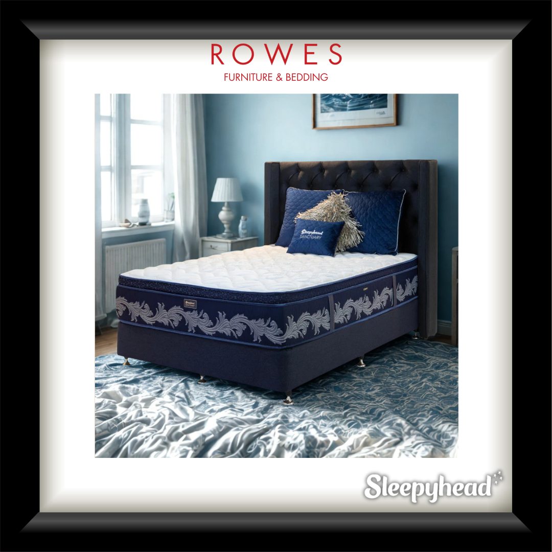 Navy blue bed with decorative pillows in a bedroom setting, featuring Rowes Furniture & Bedding branding.
