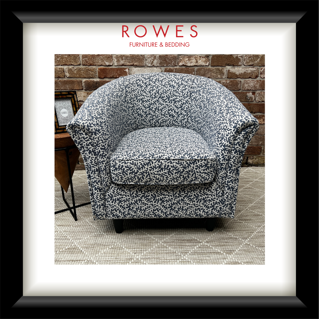 Floral-patterned armchair in a room with a brick wall and rug.
