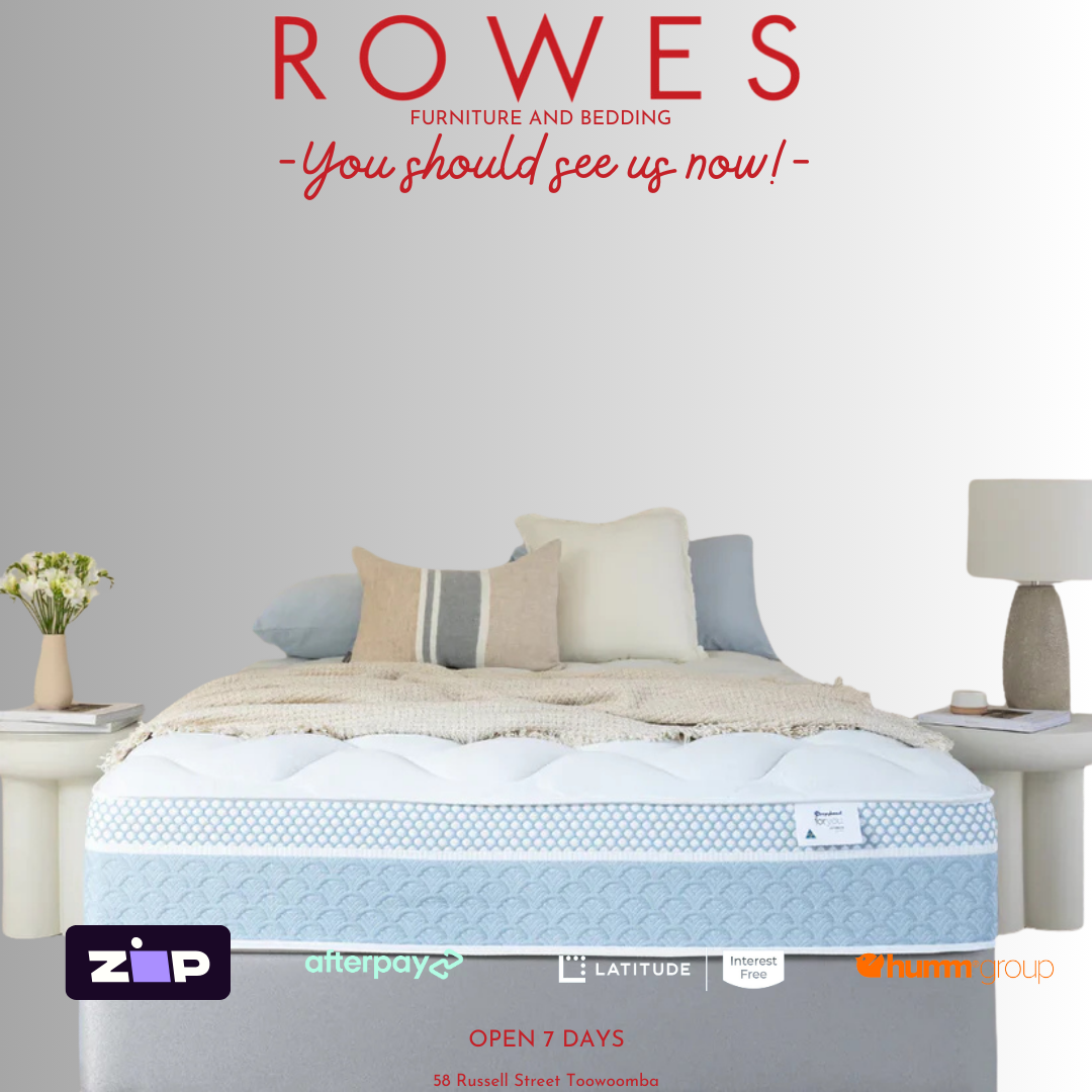A well-presented mattress on a bed frame, with a headboard, pillows, and a quilt. The room is brightly lit and has a light interior design.