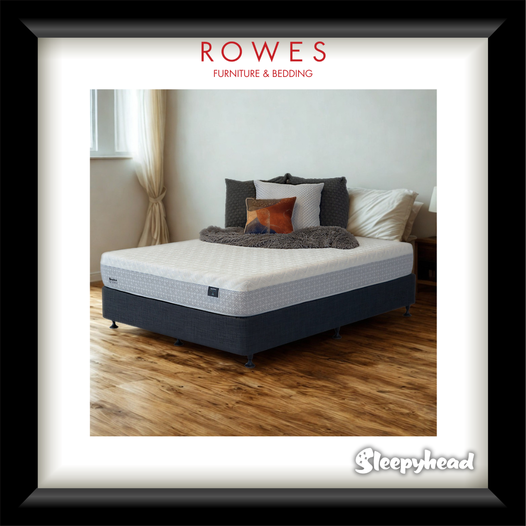 Bed with pillows and blankets in a room, featuring 'Rowes Furniture & Bedding' and 'Sleepyhead' logos.