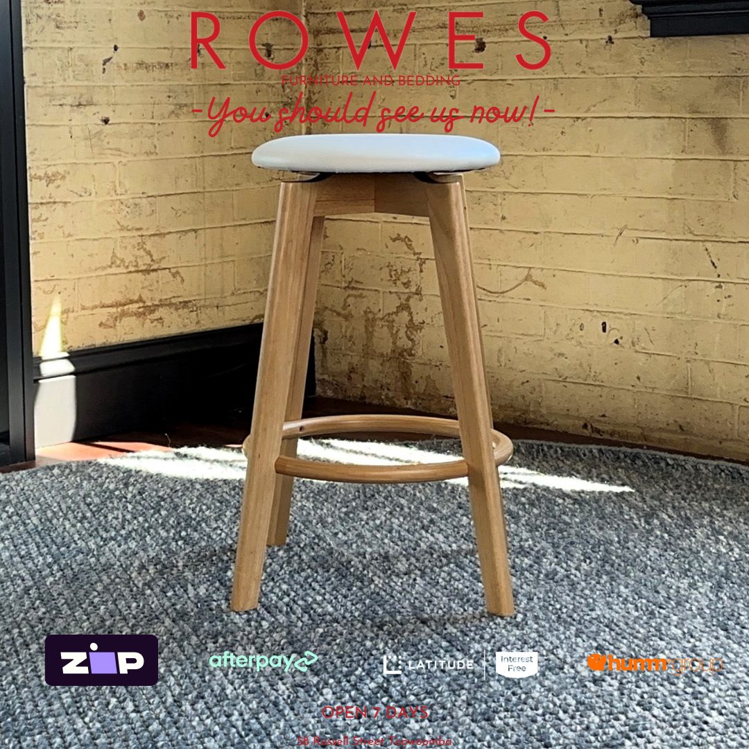Wooden bar stool with a white cushioned seat against a brick wall, featuring the brand 'Rowes'.