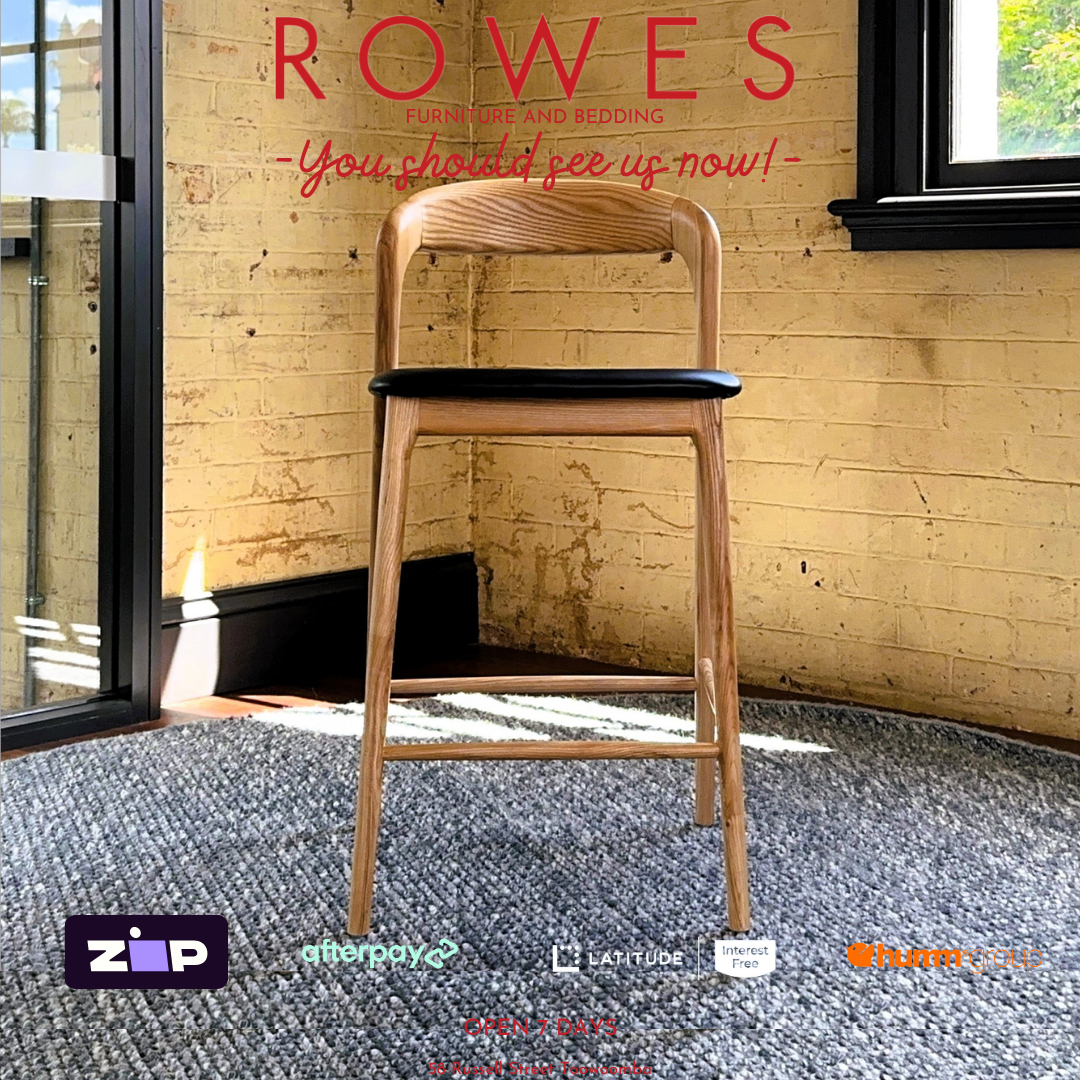Wooden bar stool in a room with a window and 'Rowes' branding.