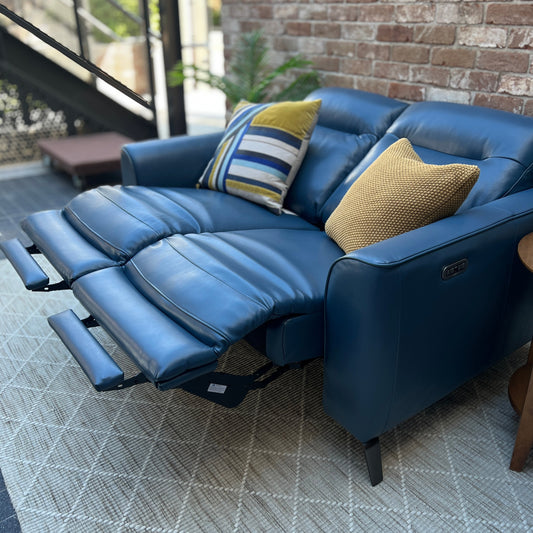 Blue leather LaZboy theatre suite on a pale rug, set against a brick wall