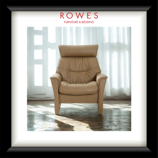 Beige leather armchair in a room with light filtering through sheer curtains, branded 'Rowes Furniture & Bedding'.