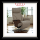 Beige recliner chair with wooden armrests in a room with large windows and plants, featuring the Rowes Furniture & Bedding logo.