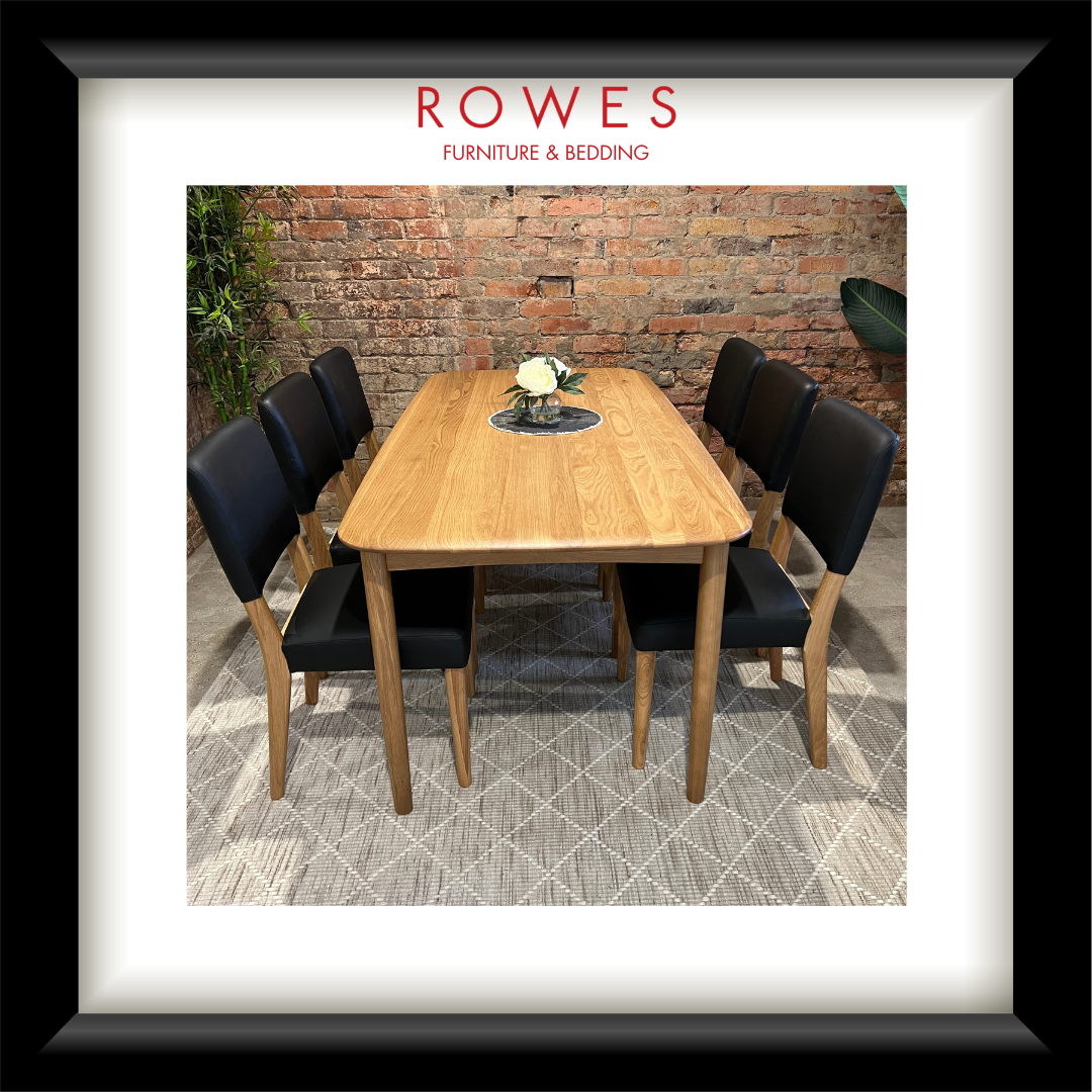 An oak dining table in a comfortable room with leather dining chairs and the Rowes branding