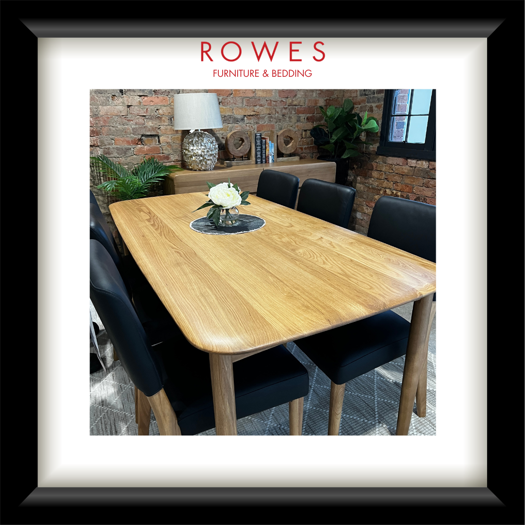An oak dining table in a comfortable room with leather dining chairs and the Rowes branding