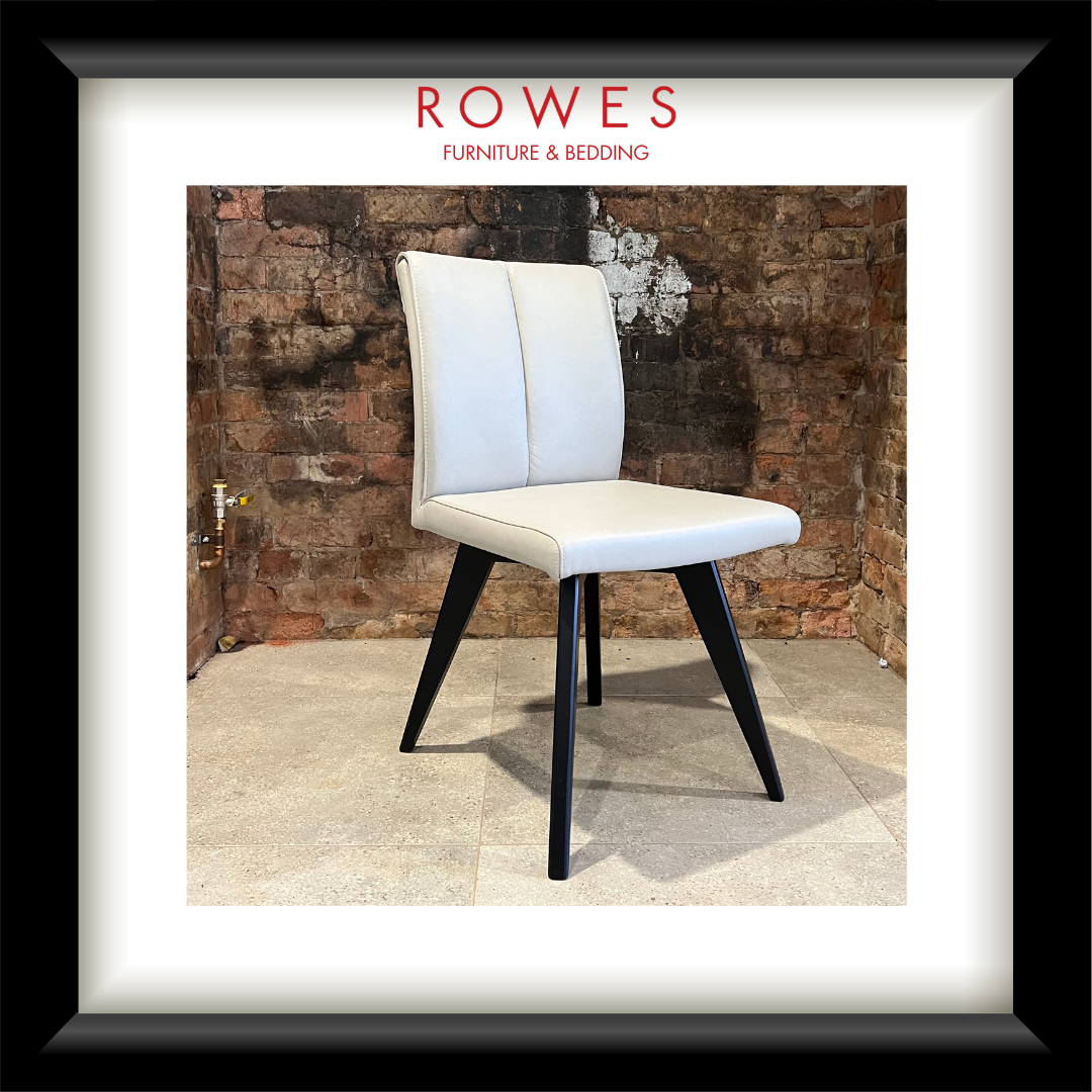 A beige leather dining chair with black legs on a tiled floor with Rowes branding in the image.