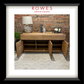 A framed furniture catalog or print featuring a wooden sideboard with open doors, styled with a lamp, books, and decor against a brick wall. The image is matted with a white border and enclosed in a black frame, with the text 'ROWES FURNITURE & BEDDING' at the top.