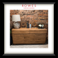 A framed image containing an oak buffet with a lamp and some books on the top surface. The frame has the Rowes branding. 