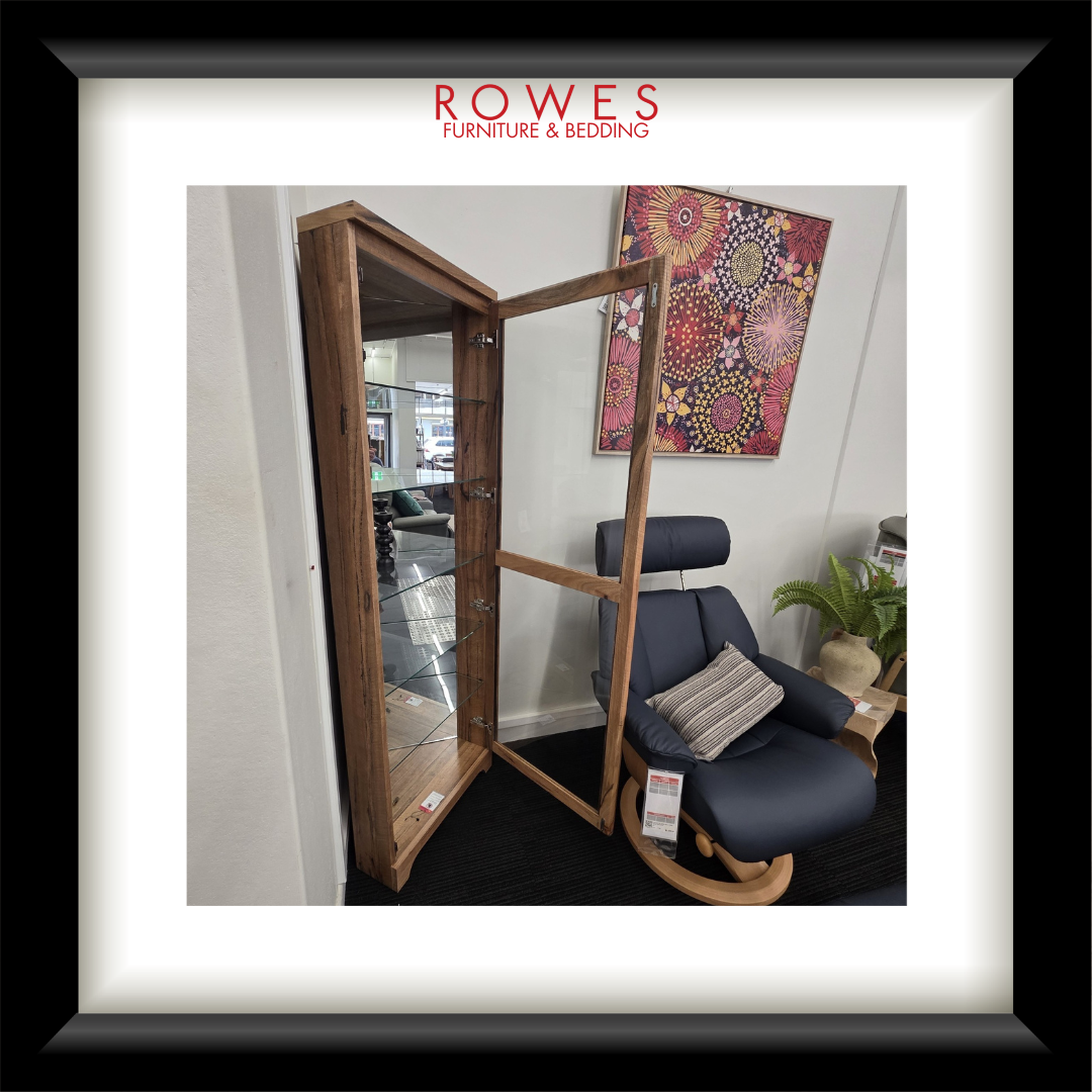 Furniture store interior with a wooden floor mirror and blue armchair, featuring Rowes Furniture & Bedding logo.
