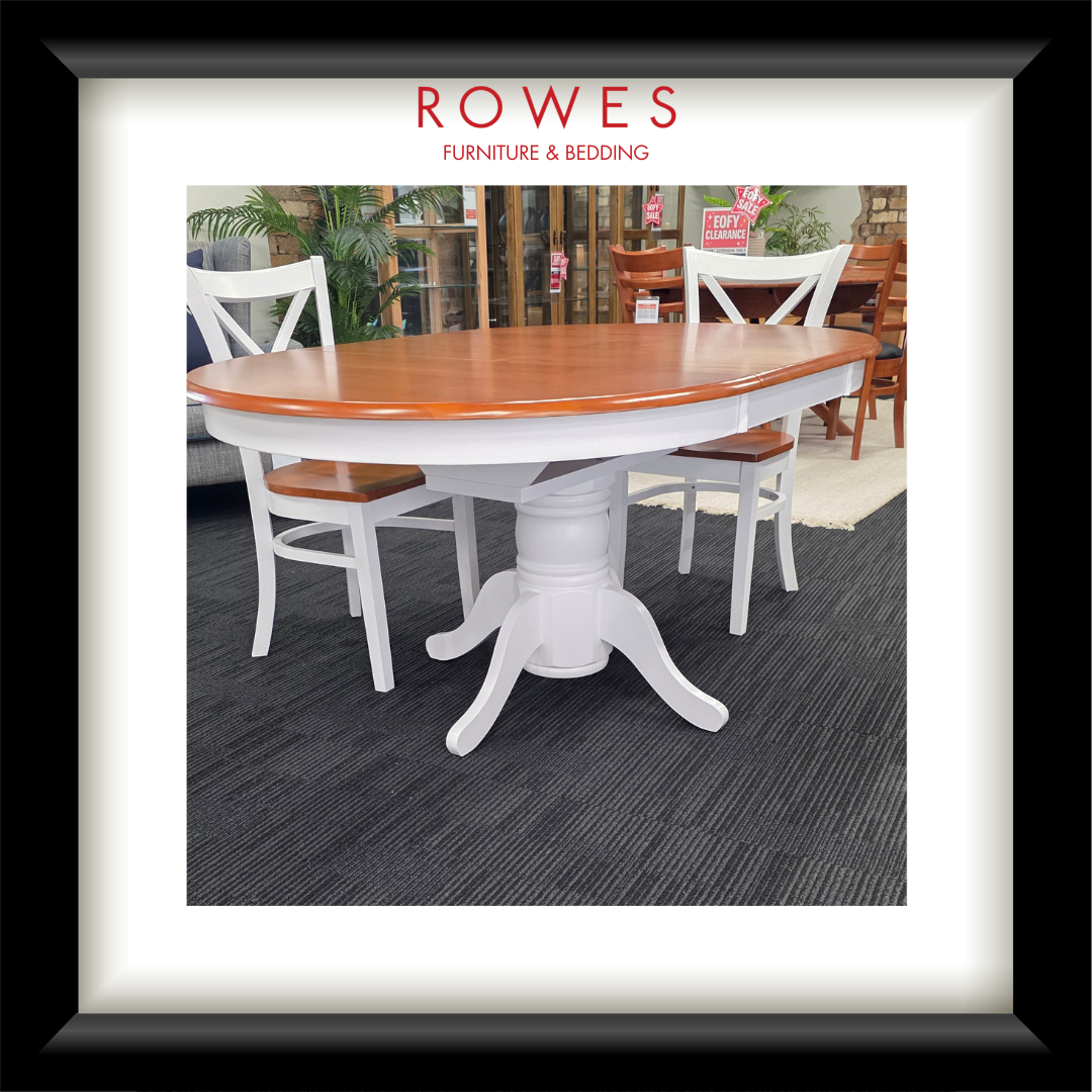 A white dining table surrounded by matching chairs. The top of the dining table and the seats of the chairs are all natural timber coloured. The Rowes branding is prominent. 