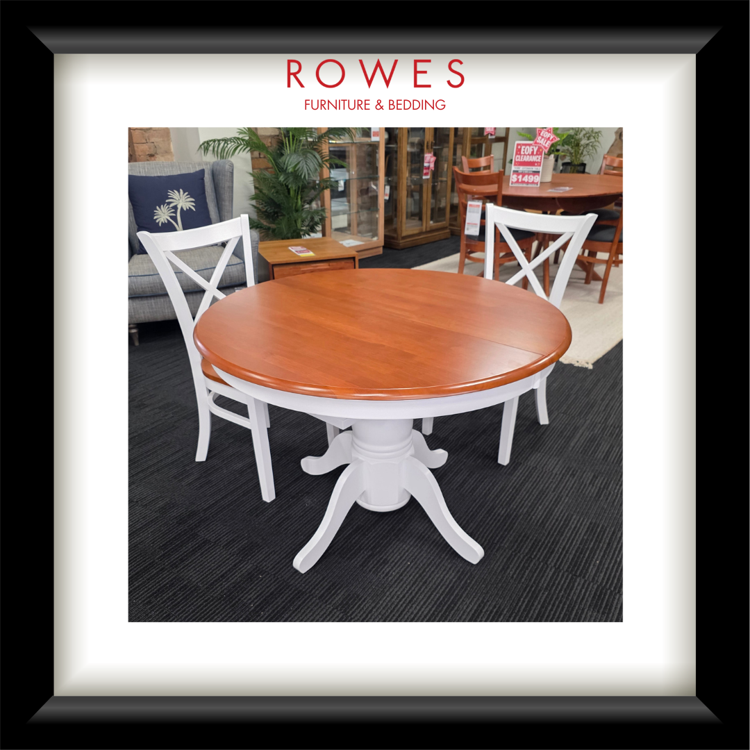 A white dining table surrounded by matching chairs. The top of the dining table and the seats of the chairs are all natural timber coloured. The Rowes branding is prominent. 