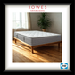 Gray mattress on a wooden bed frame in a room with a plant and window, branded as Rowes Furniture & Bedding.