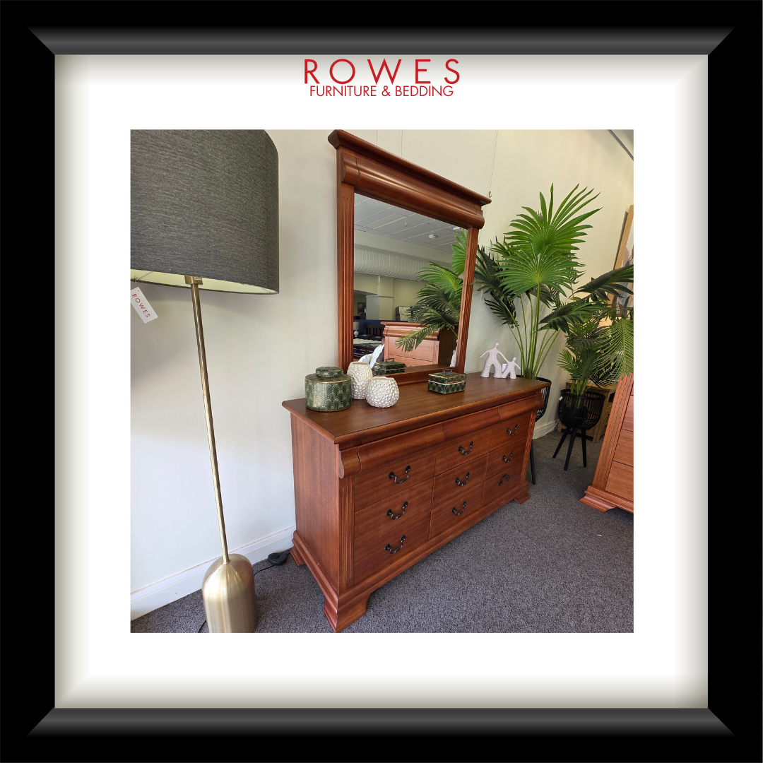 Wooden dresser with mirror and lamp in a room setting, featuring Rowes Furniture & Bedding logo.