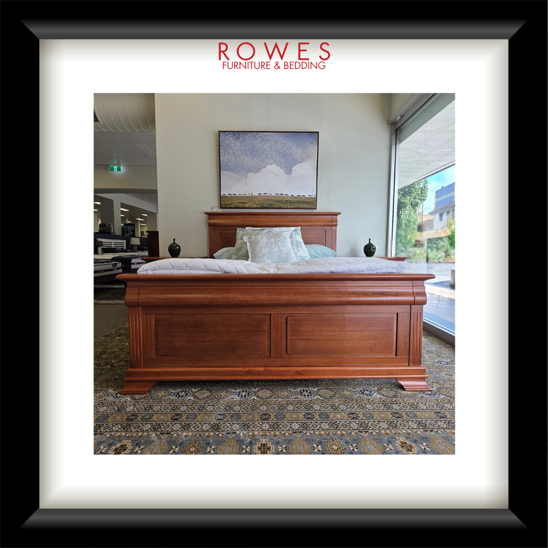 Wooden bed in a showroom with 'Rowes Furniture & Bedding' branding.