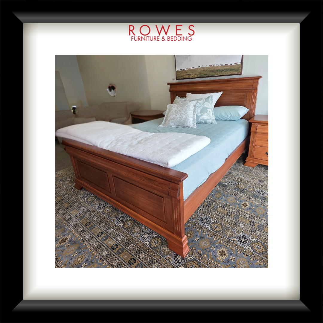 Wooden bed with bedding in a bedroom setting, featuring Rowes Furniture & Bedding logo.