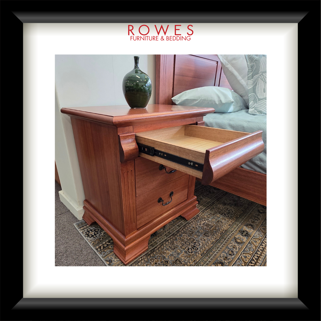 Wooden nightstand with open drawer in a bedroom setting, featuring Rowes Furniture & Bedding logo.