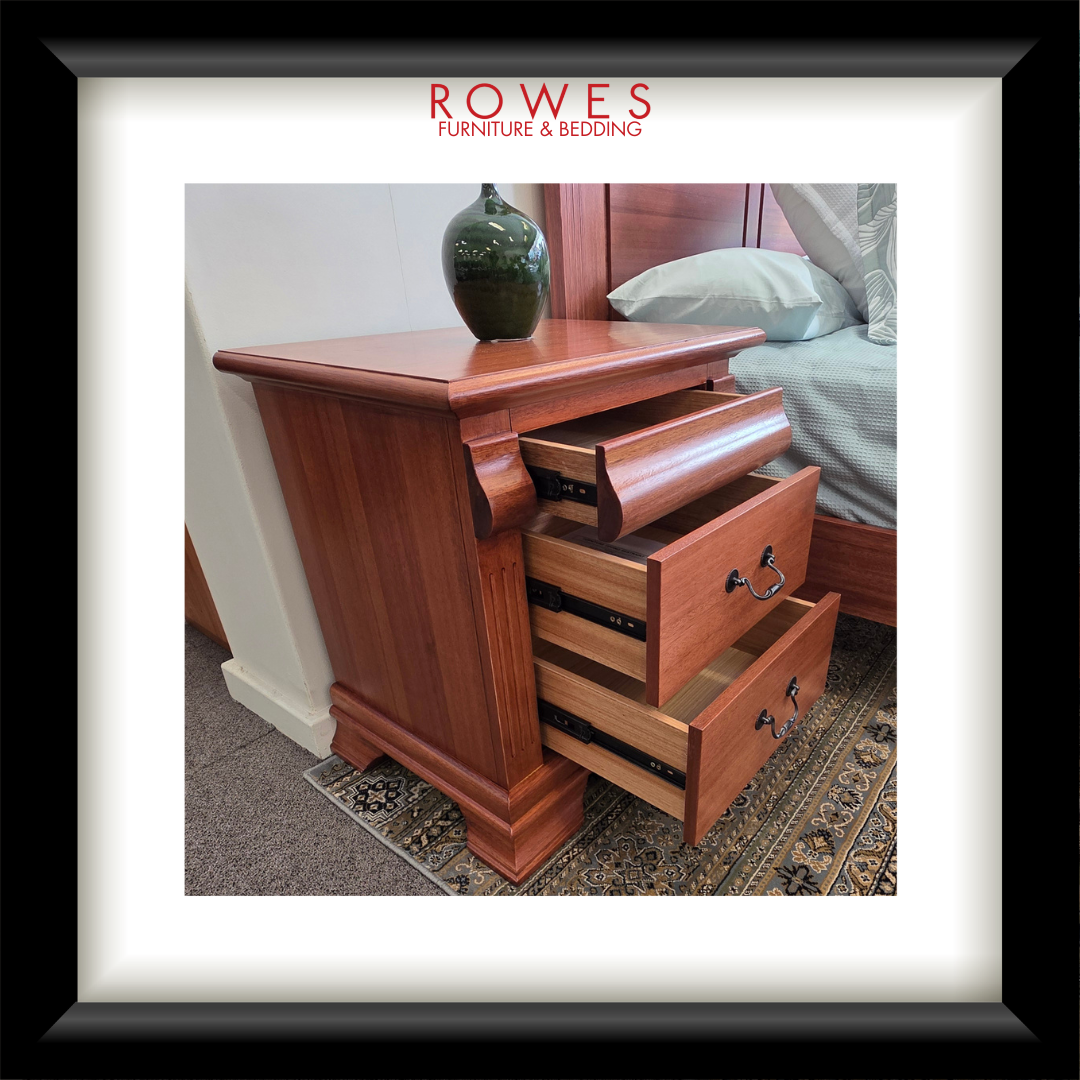 Wooden nightstand with open drawers in a bedroom setting, featuring Rowes Furniture & Bedding logo.