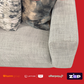 Gray sofa with camouflage pillows on a red background featuring payment brand logos.