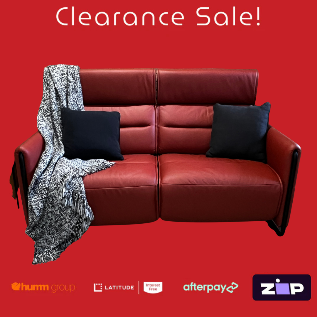 Red leather sofa with black pillows and a blanket on a red background, featuring clearance sale text and payment logos.