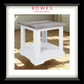 A framed product photo of a small end table with a white distressed base and a weathered gray-brown wood top, shown inside a black frame with a white mat. The brand name 'ROWES FURNITURE & BEDDING' is printed at the top of the image.