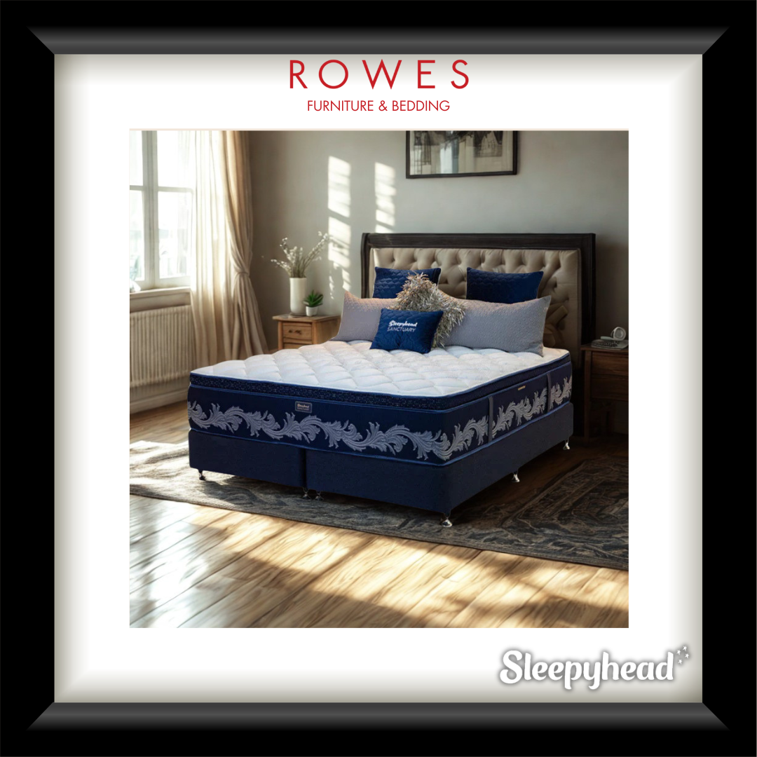 Blue and white mattress with decorative pillows on a bed in a bedroom setting, featuring Rowes Furniture & Bedding branding.