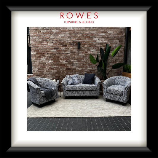 Furniture set with patterned chairs and a sofa against a brick wall, featuring 'Rowes Furniture & Bedding' branding.