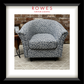 Floral-patterned armchair in a room with a brick wall and rug.