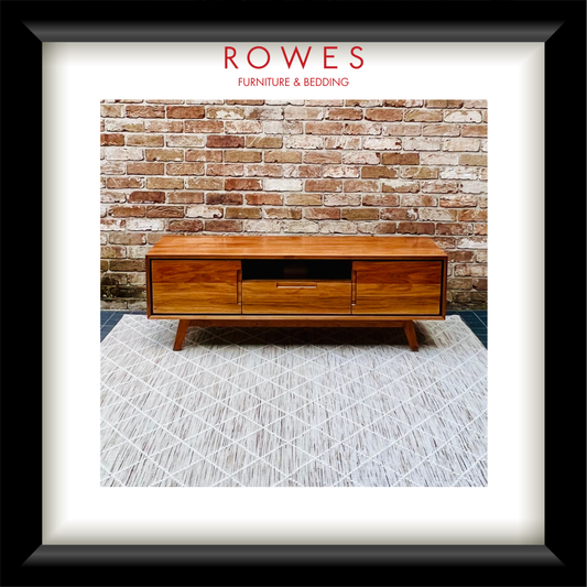 An entertainment unit on a beige rug set against a brick wall with the Rowes branding.