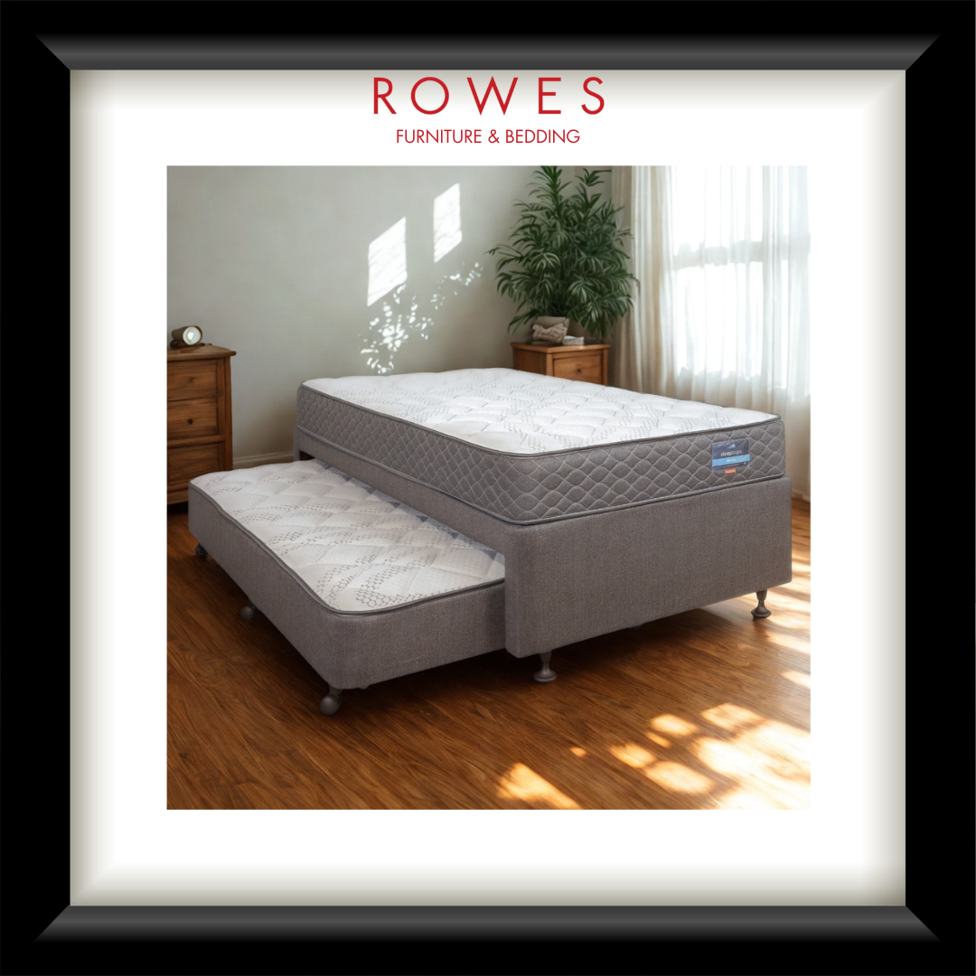 A framed product advertisement for a Rowes Furniture & Bedding mattress bed with an under-bed storage tray, shown in a styled bedroom setting with a black frame and white mat.