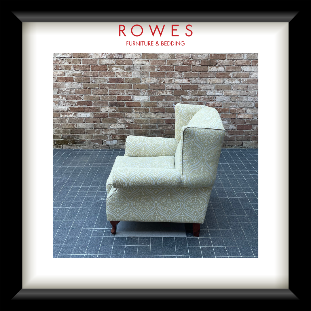 Patterned armchair against a brick wall with 'Rowes Furniture & Bedding' branding.