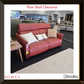 Red sofa with cushions in a showroom setting, featuring 'Rowes' and 'Stressless' branding.