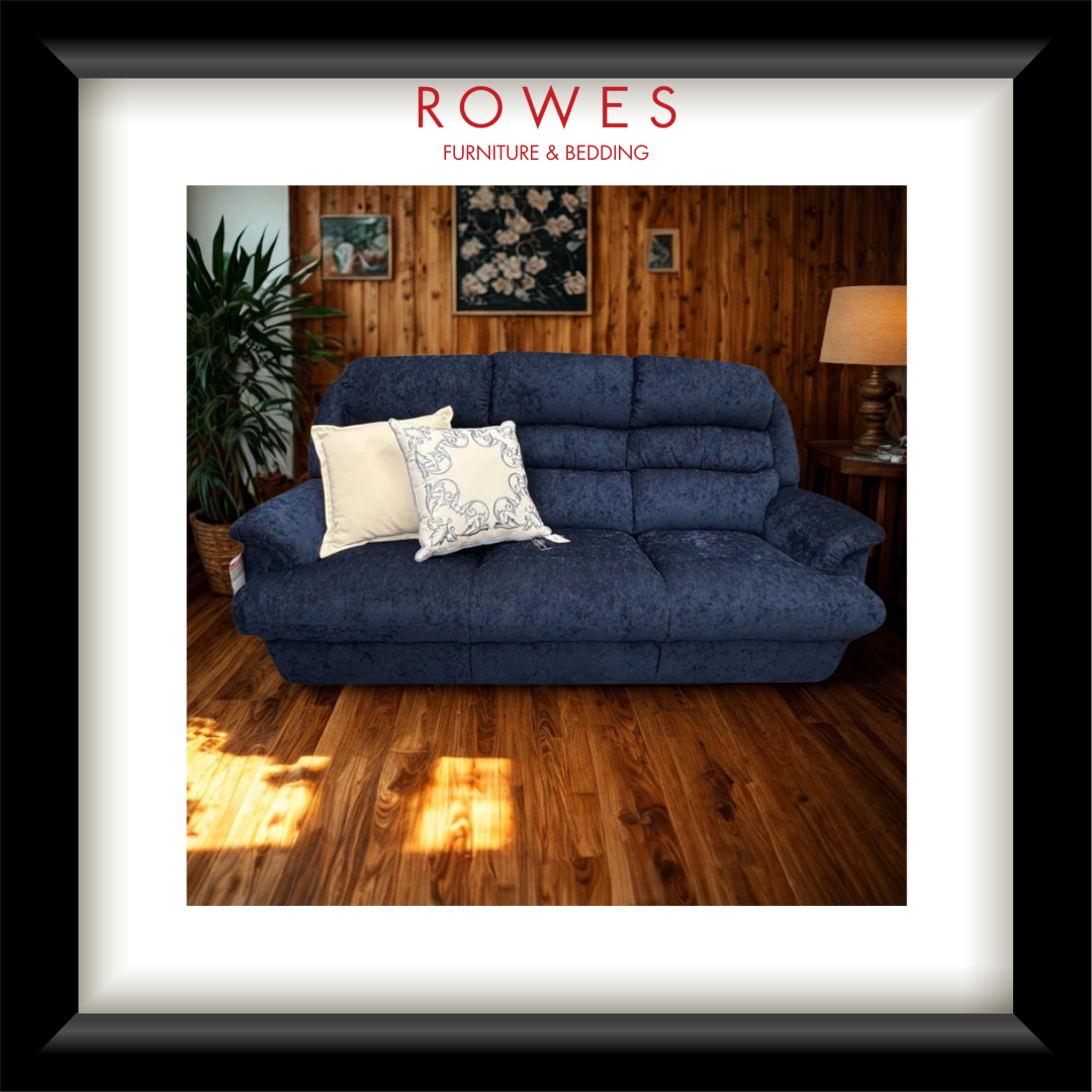 Blue sofa with decorative pillows in a room setting, featuring 'Rowes Furniture & Bedding' branding.