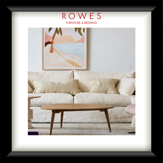 Living room with a sofa, coffee table, and wall art, featuring Rowes Furniture & Bedding logo.