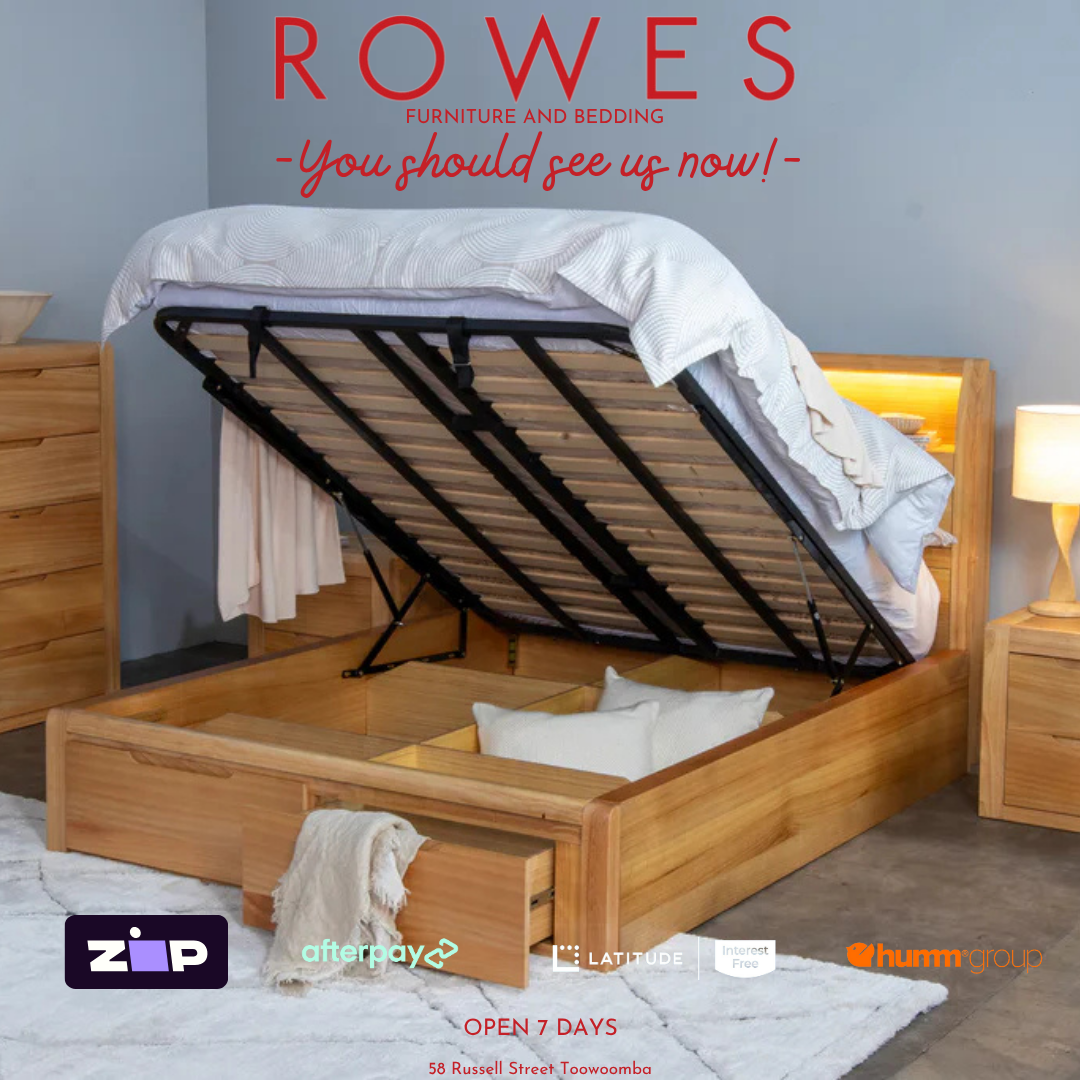 Wooden bed with open drawers in a bedroom setting, featuring 'Rowes' furniture and bedding.