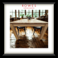 A framed furniture catalog photo showing a light oak dining table with black chairs, presented in a white mat and black frame. The top of the print features the text 'ROWES FURNITURE & BEDDING'.
