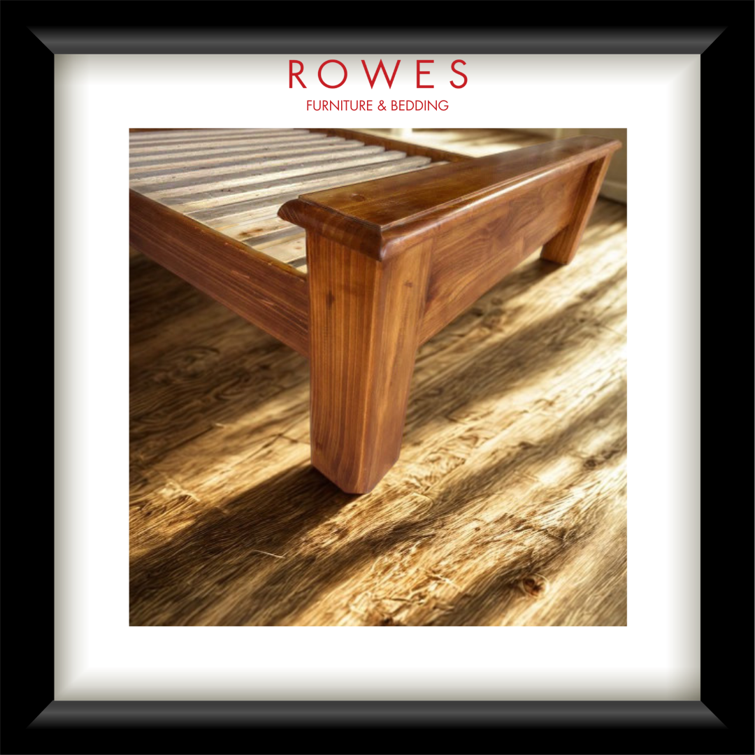 A large timber bed in a well lit room with the Rowes branding