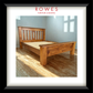 A large timber bed in a well lit room with the Rowes branding