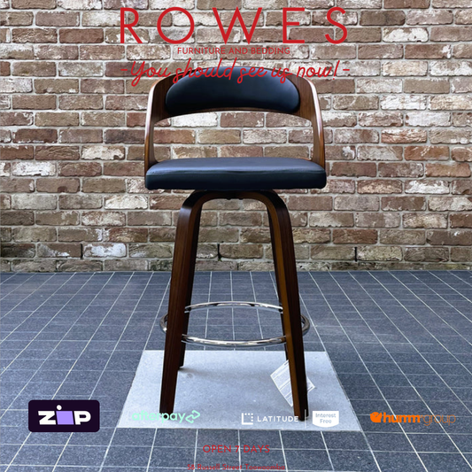 Wooden bar stool with black cushioned seat against a brick wall, featuring 'ROWES' branding.