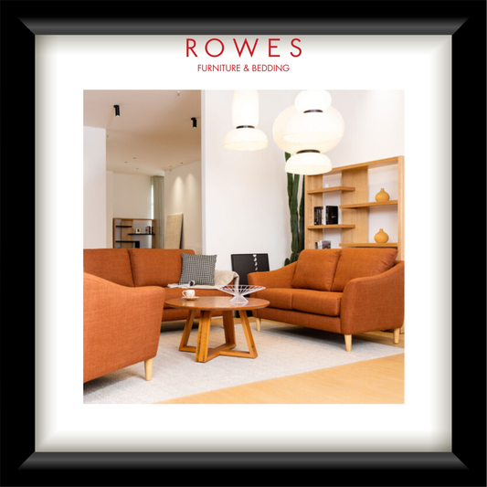 Living room with orange sofas and wooden coffee table, featuring ROWES Furniture & Bedding logo.