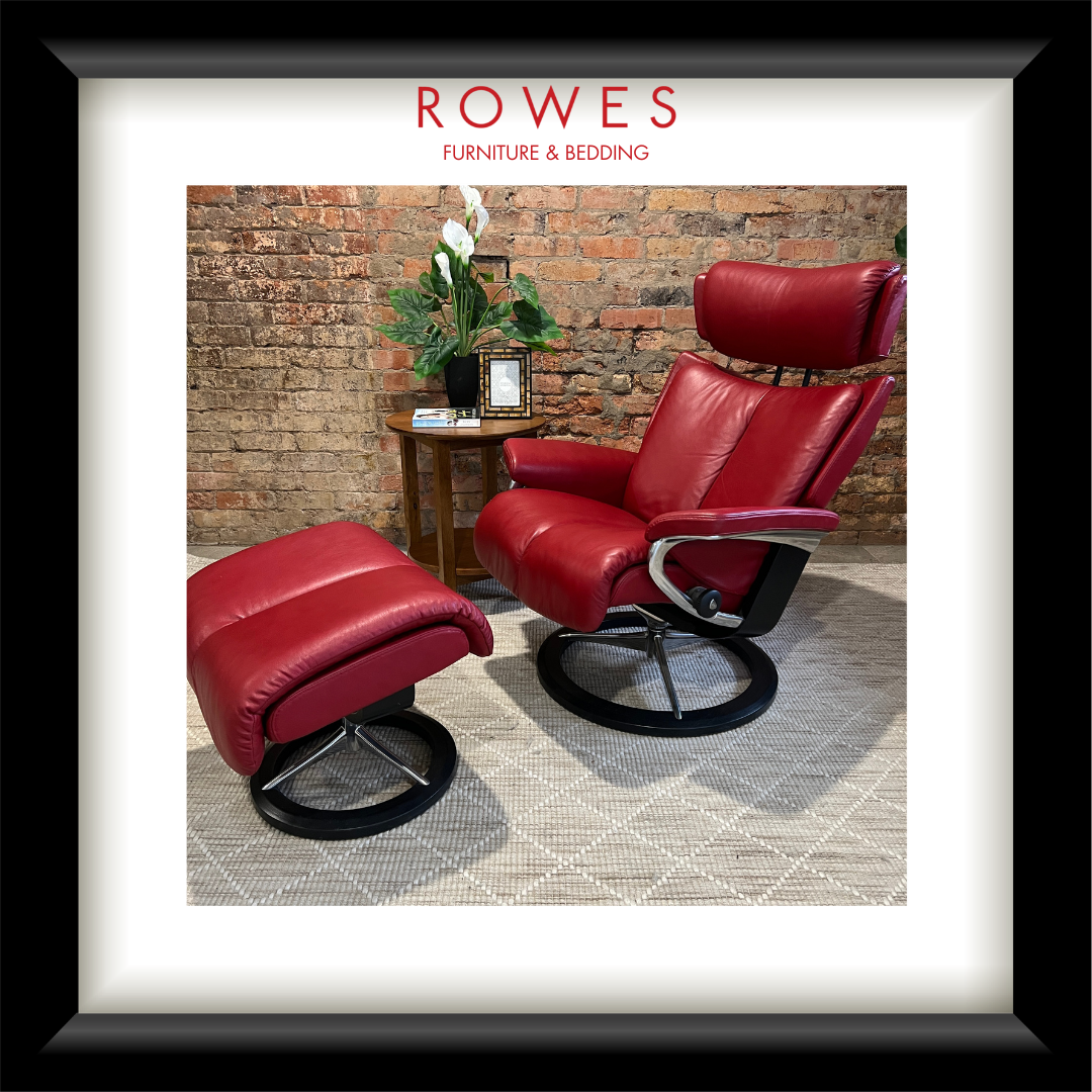 Red leather recliner chairs in a room with a brick wall and a plant.