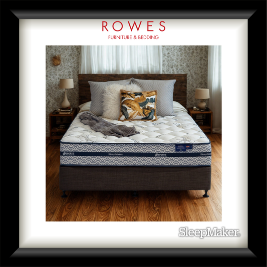 Bed with pillows and blankets on a wooden floor, featuring Rowes Furniture & Bedding branding.