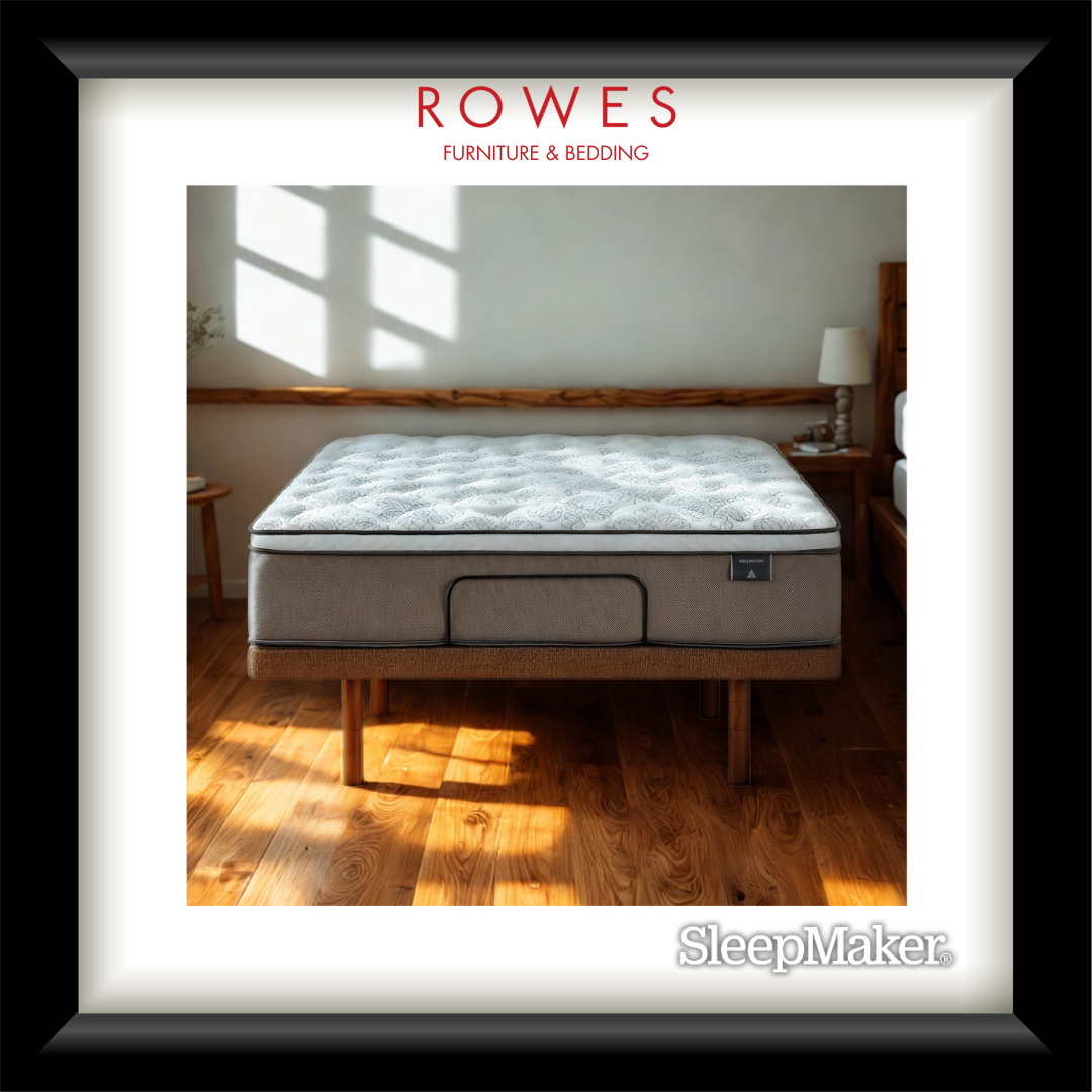 Mattress on a wooden bed frame in a room with sunlight streaming through a window, branded 'Rowes Furniture & Bedding' and 'SleepMaker'.